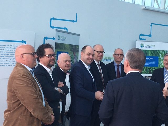 Gedeputeerden Beurskens (5e vl) en Mackus (6e vl) in gesprek met ondernemers, opening Bio Treat Center