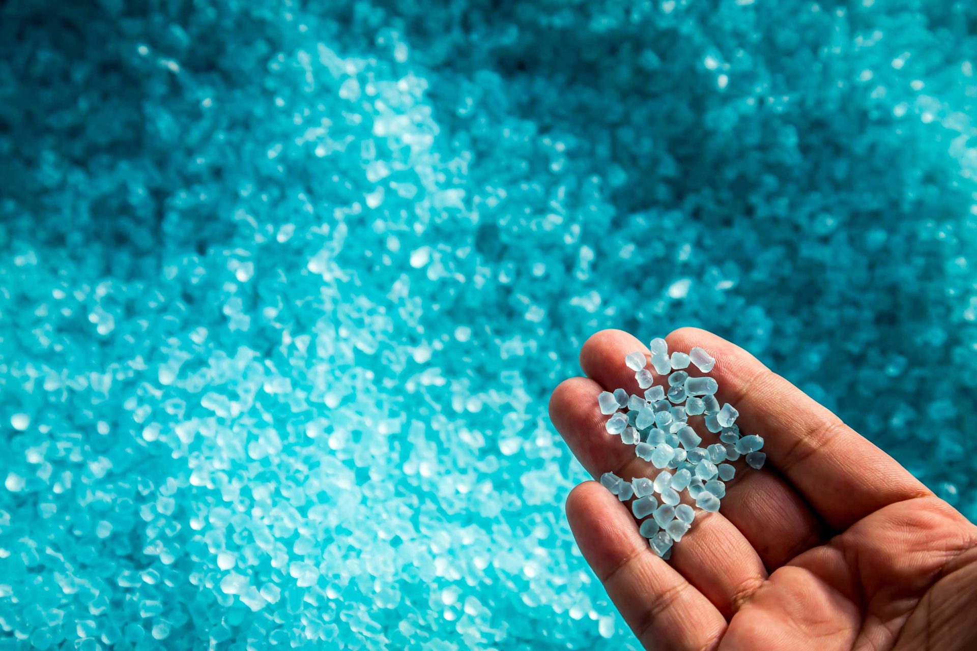 Hand met plastic korrels