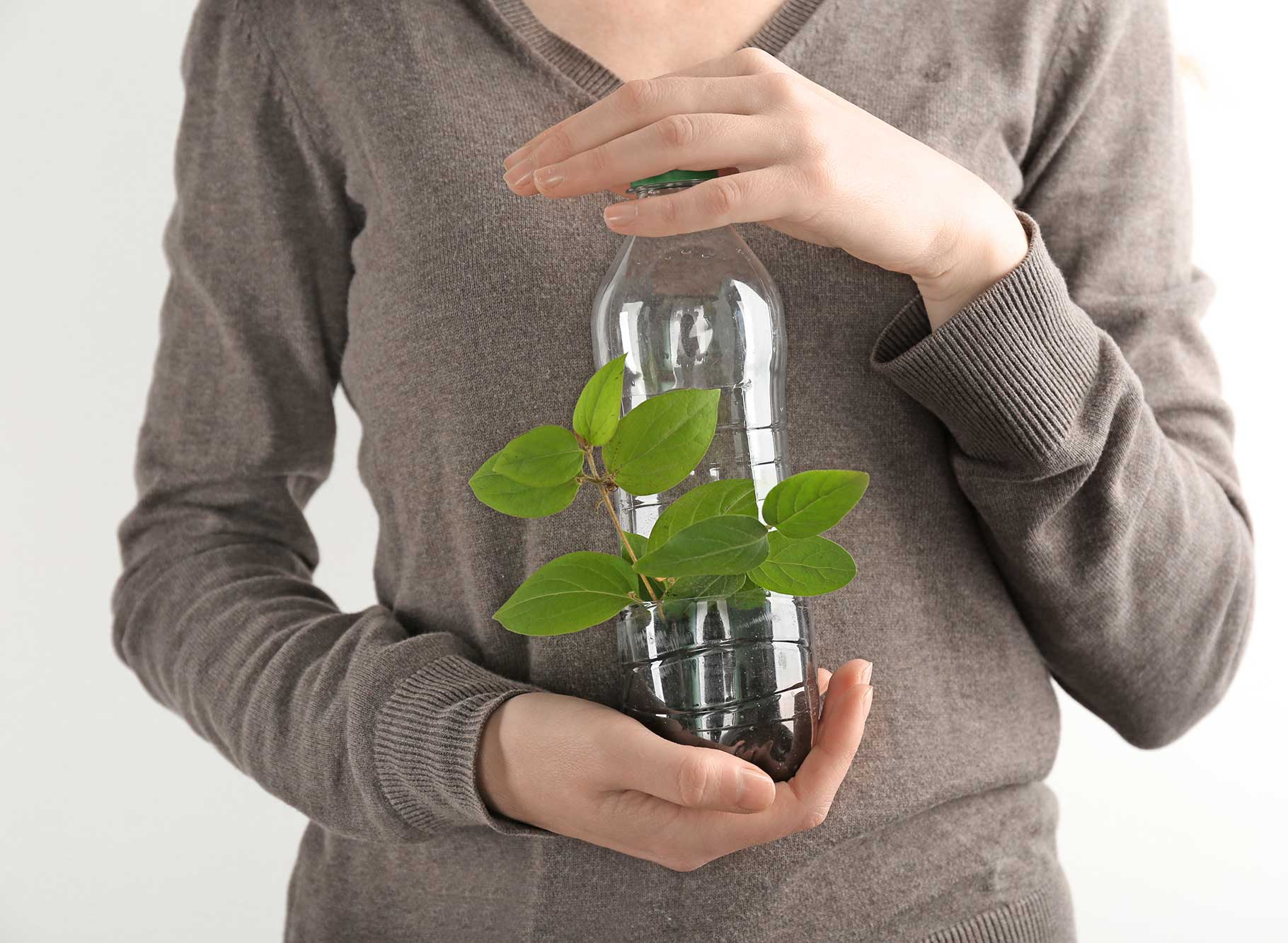 Vrouw met plastic fles, plantje