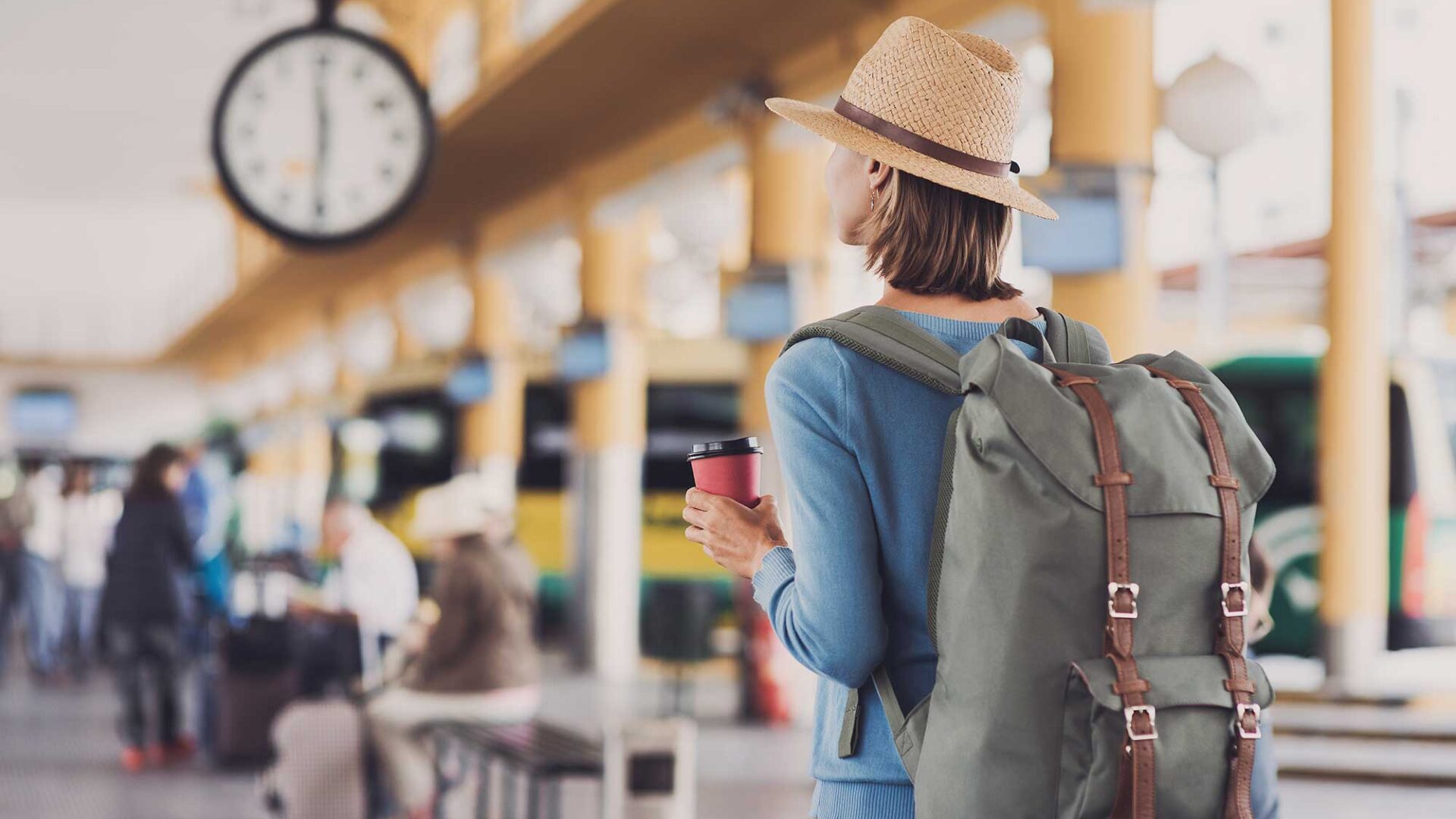 Vrouw met een bekertje koffie op het station