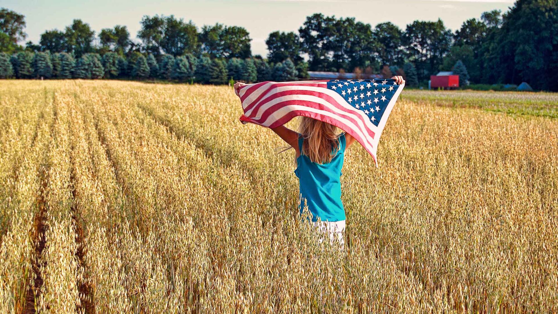 Meisje in korenveld met Amerikaanse vlag