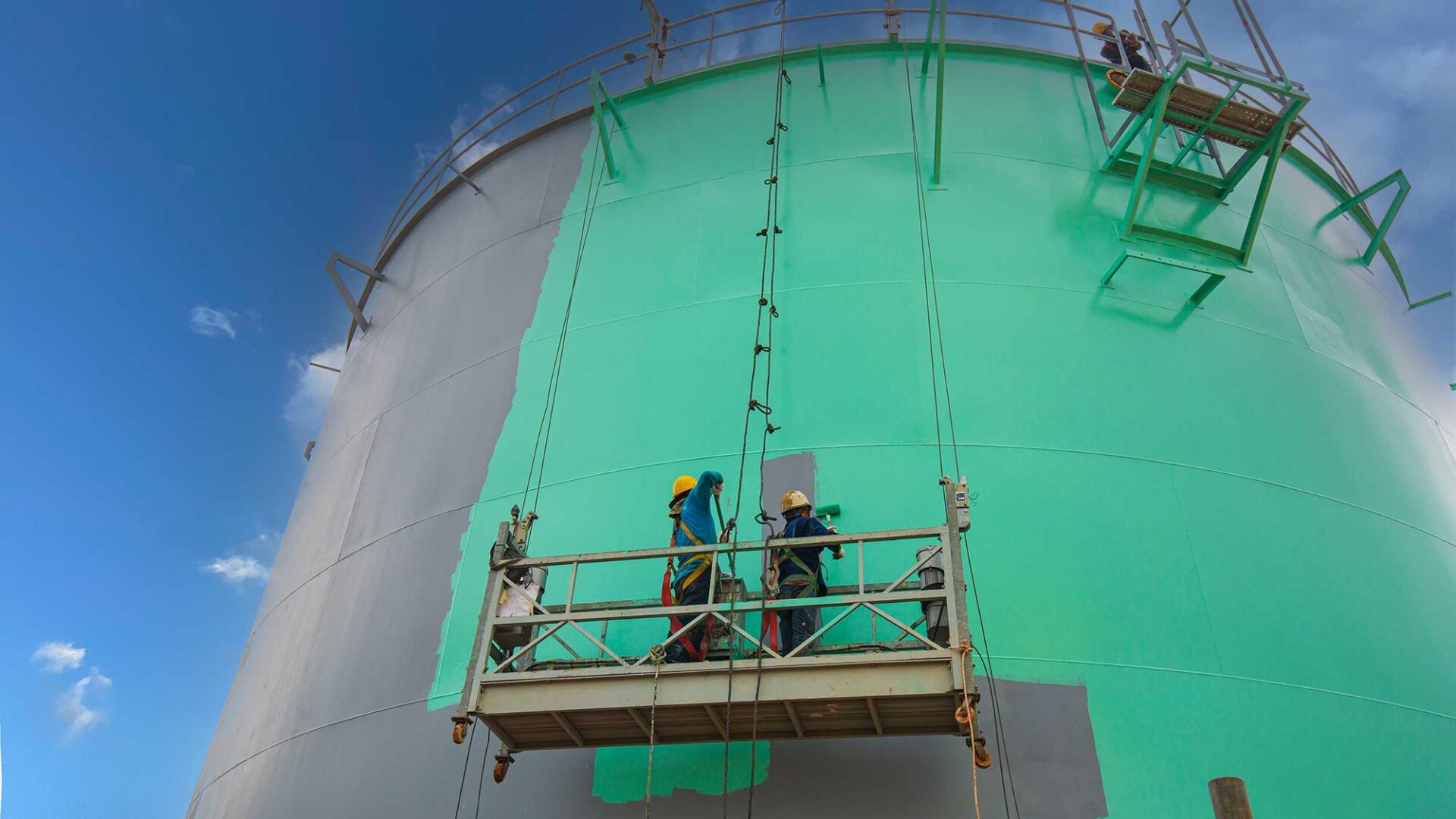 Een opslagtank wordt groen geverfd